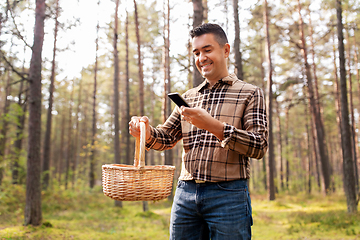 Image showing man using smartphone to identify mushroom