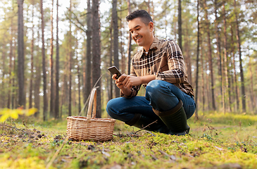 Image showing man using smartphone to identify mushroom