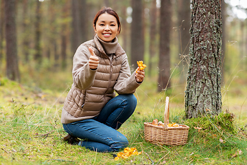 Image showing woman with mushrooms showing thumbs up in forest