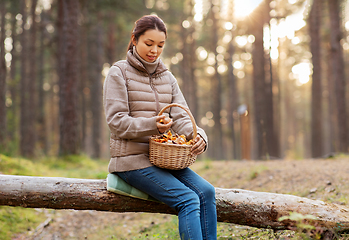 Image showing woman with mushrooms in basket in autumn forest