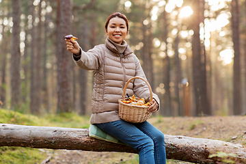 Image showing woman with mushrooms in basket in autumn forest