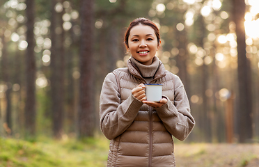 Image showing asian woman with mug drinking tea in forest