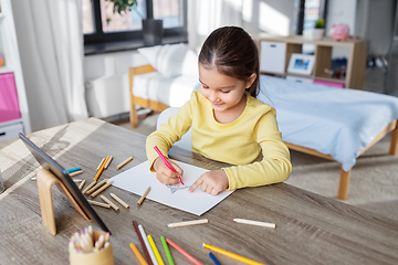 Image showing little girl drawing with coloring pencils at home