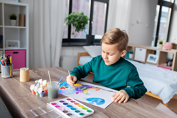 Image showing boy with colors and brush drawing picture at home