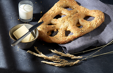 Image showing close up of cheese bread, butter, knife and milk