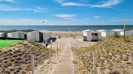 Image showing View from dunes on North Sea city beach on a sunny summer weekend. Typical pavilions. Path to North sea beach. Zandvoort, Netherlands