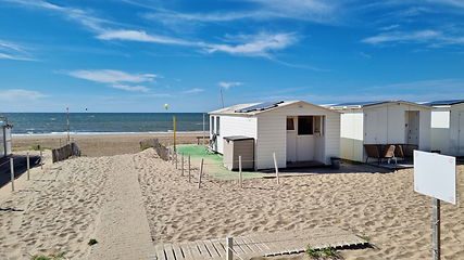 Image showing View from dunes on North Sea city beach on a sunny summer weekend. Typical pavilions. Path to North sea beach. Zandvoort, Netherlands