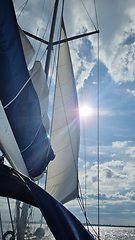 Image showing Sailing yacht boat on seawater at sunrise with sun flare and outdoor lifestyle