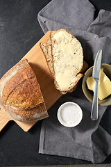 Image showing close up of bread, butter, knife and salt on towel