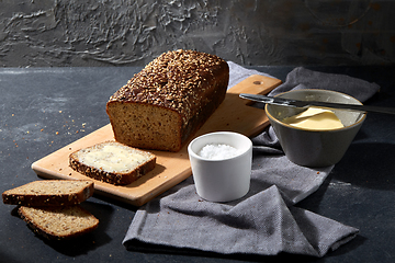 Image showing close up of bread, butter, knife and salt on towel