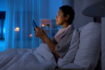 Image showing woman with tablet pc in bed at home at night