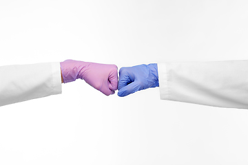 Image showing hands of doctors in gloves make fist bump gesture