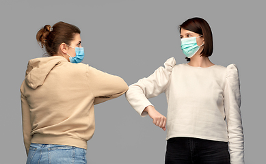 Image showing women in masks making elbow bump greeting gesture