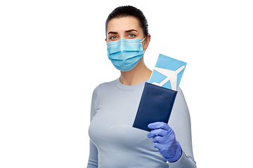 Image showing young woman in mask with air ticket and passport