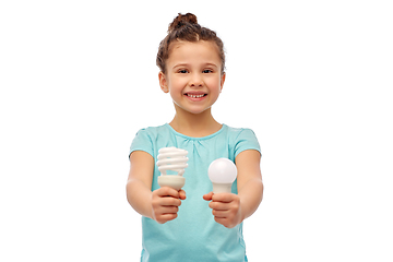 Image showing smiling girl comparing different light bulbs