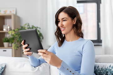 Image showing happy smiling young woman with tablet pc at home