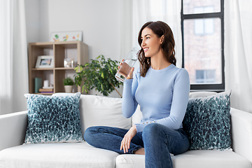 Image showing woman drinking water from glass bottle at home