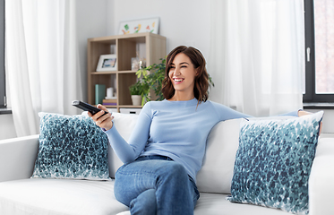 Image showing happy woman watching tv at home