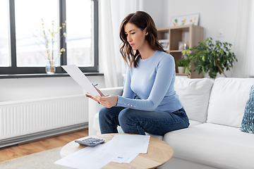 Image showing woman with papers and calculator at home