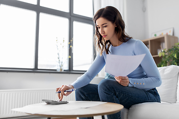 Image showing woman with papers and calculator at home