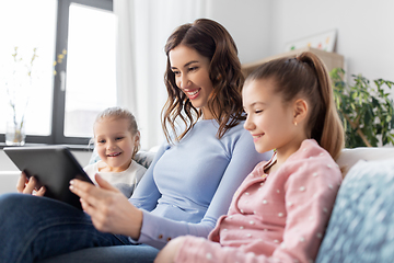 Image showing happy mother and daughters with tablet pc at home