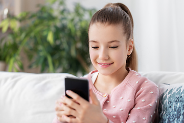 Image showing happy smiling little girl with smartphone at home