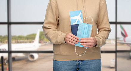 Image showing woman with mask, passport and ticket at airport