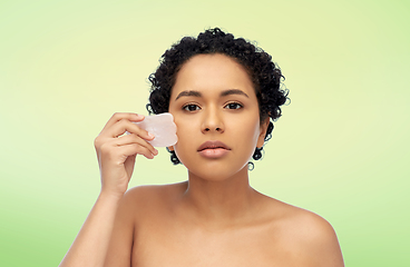 Image showing young woman massaging her face with gua sha tool