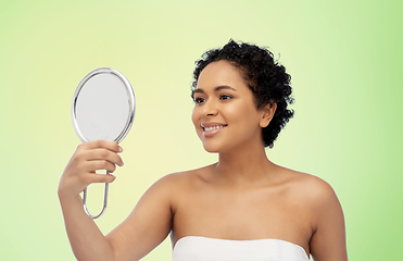 Image showing smiling african american woman looking to mirror