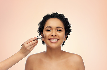 Image showing happy woman and hand of make up artist with brush