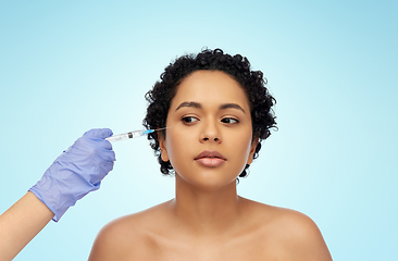 Image showing face of african woman and hand with syringe