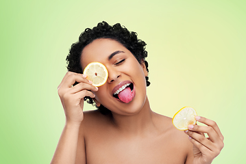 Image showing african american woman making eye mask of lemons