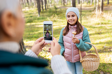 Image showing grandma photographing granddaughter with mushrooms