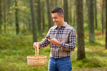 Image showing man using smartphone to identify mushroom