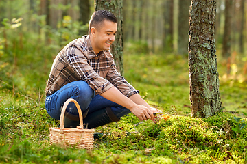 Image showing happy man with basket picking mushrooms in forest