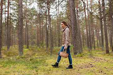 Image showing young woman picking mushrooms in autumn forest