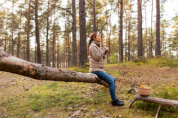 Image showing asian woman with mushrooms drinking tea in forest
