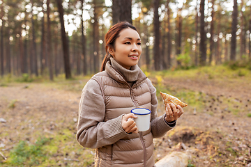 Image showing woman with mushrooms drinks tea and eats in forest