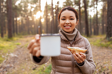 Image showing woman with mushrooms drinks tea and eats in forest