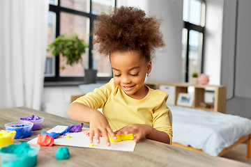 Image showing little girl with modeling clay playing at home