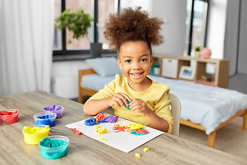 Image showing little girl with modeling clay playing at home