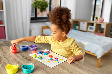 Image showing little girl with modeling clay playing at home