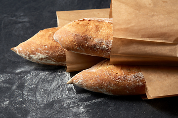 Image showing close up of baguette bread in paper bags on table