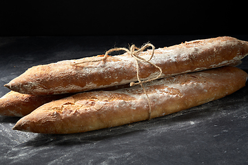 Image showing pile of baguette bread loaves tied with rope