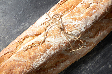 Image showing pile of baguette bread loaves tied with rope