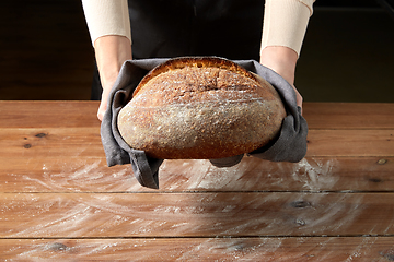 Image showing female baker with homemade bread at bakery