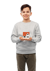 Image showing smiling boy holding house model