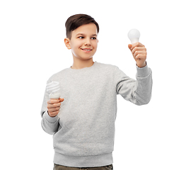 Image showing smiling boy comparing different light bulbs