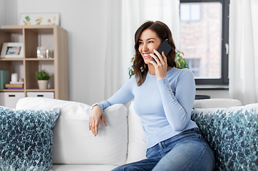 Image showing smiling woman calling on smartphone at home