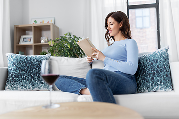 Image showing young woman reading book at home